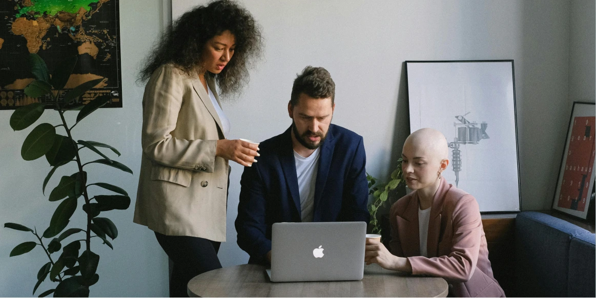 Three people working on a computer together